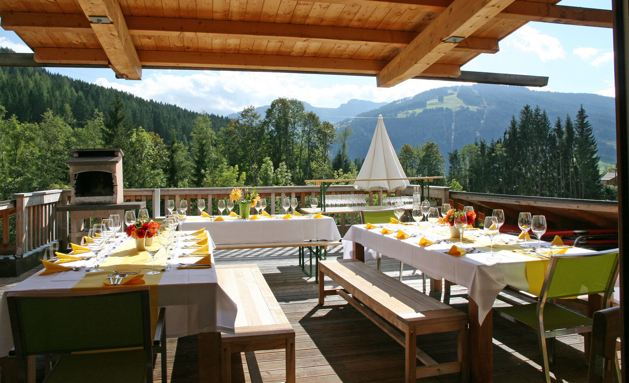 Private terrace with barbecue grill and set table in the Alpin Chalet XL in Wagrain.