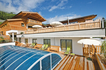 Communal pool with sun terrace at the Alpin Chalet Classic in Flachauwinkl.