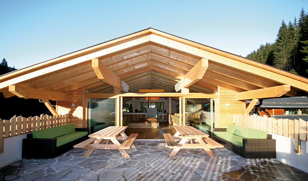 The covered terrace with outdoor sofas and picnic tables in the Alpin Chalet Large in Filzmoos.