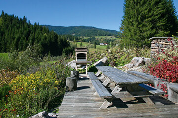 Die Terrasse mit Tischen und Sitzbänken beim Alpin Chalet Classic in Filzmoos.
