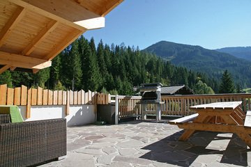 Panoramic view from the covered terrace to the sun terrace with brick BBQ.