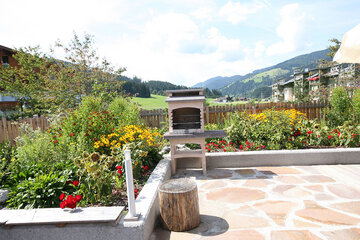 Terrasse mit gemauertem BBQ-Grill beim Alpin Chalet Classic in Flachau.