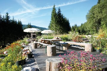 Die Terrasse mit Tischen und Sitzbänken beim Alpin Chalet Classic in Filzmoos.